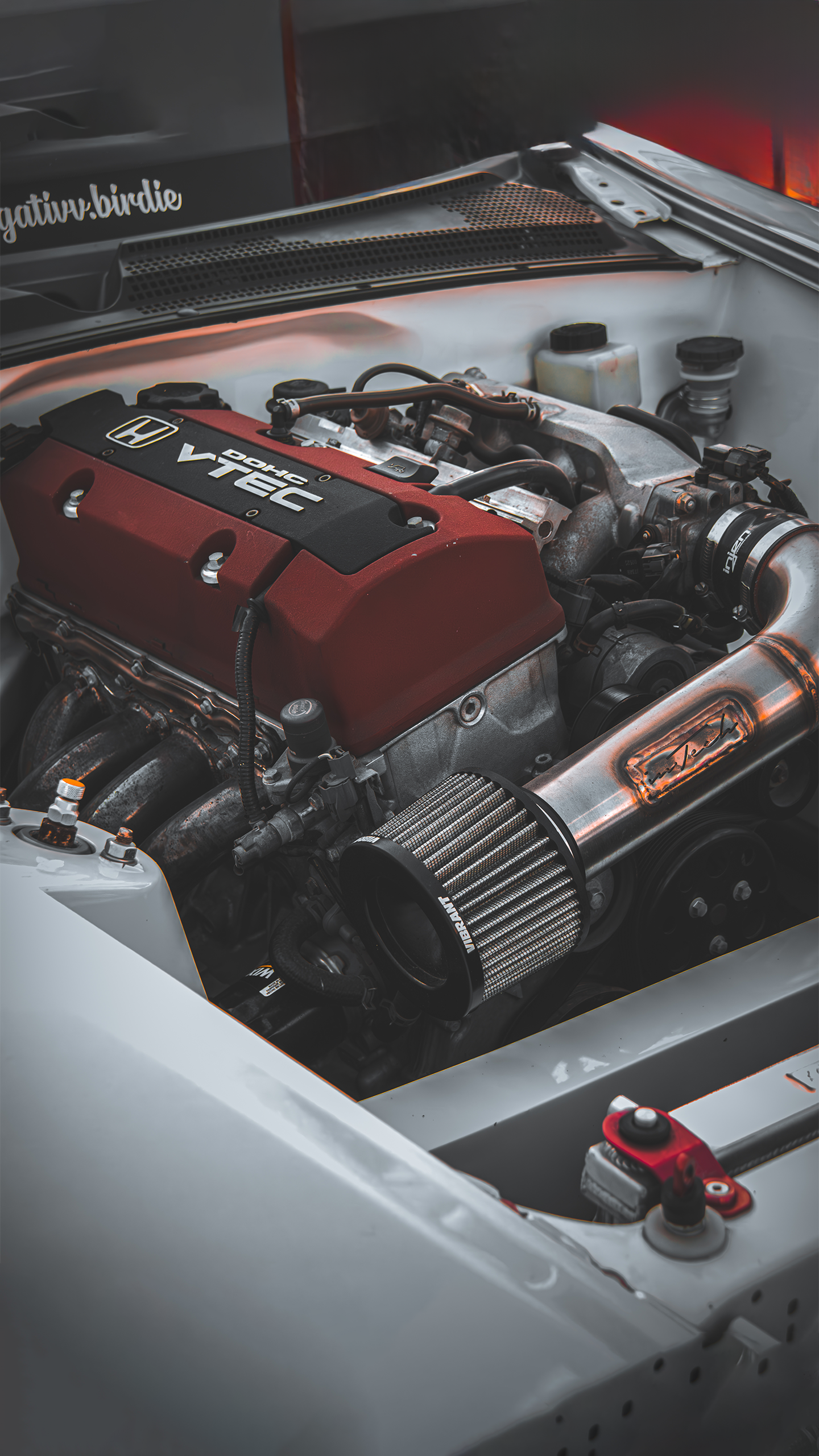 Photo of the engine bay of a mid 2000s honda in white